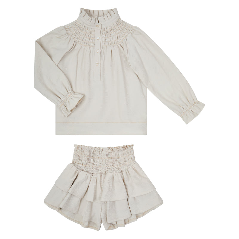 Conj. Blusa Niña Con Smock Y Aletilla Con Falda Short Ornamental Picueta Arena